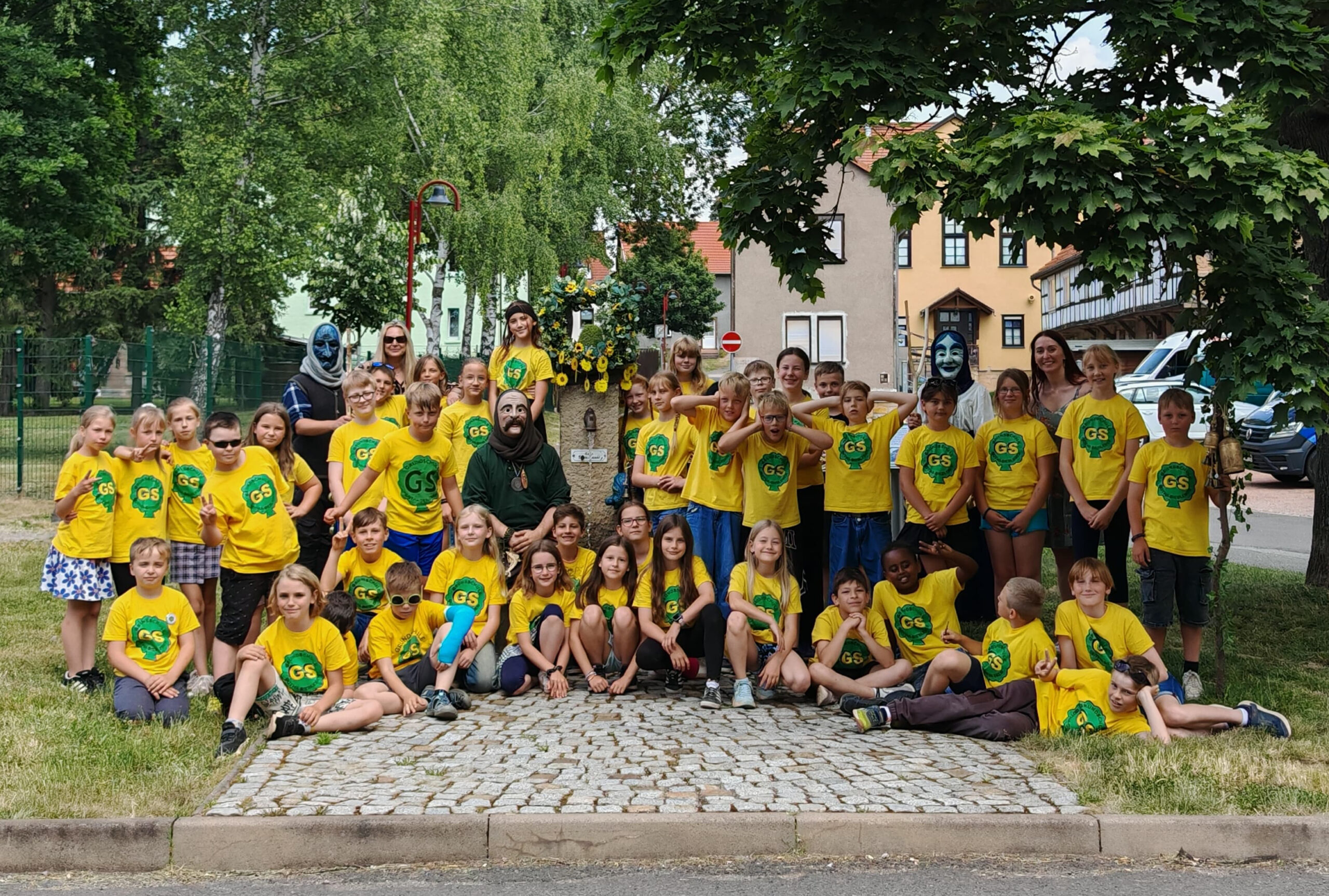 Die Siebleber Nebelgeister setzen gemeinsam mit den vierten Klassen und den Klassenlehrerinnen Frau Stender und Frau Weschke der Grundschule Siebleben die Sommerkrone auf den Laufbrunnen. Foto: Carolin Falkenstein